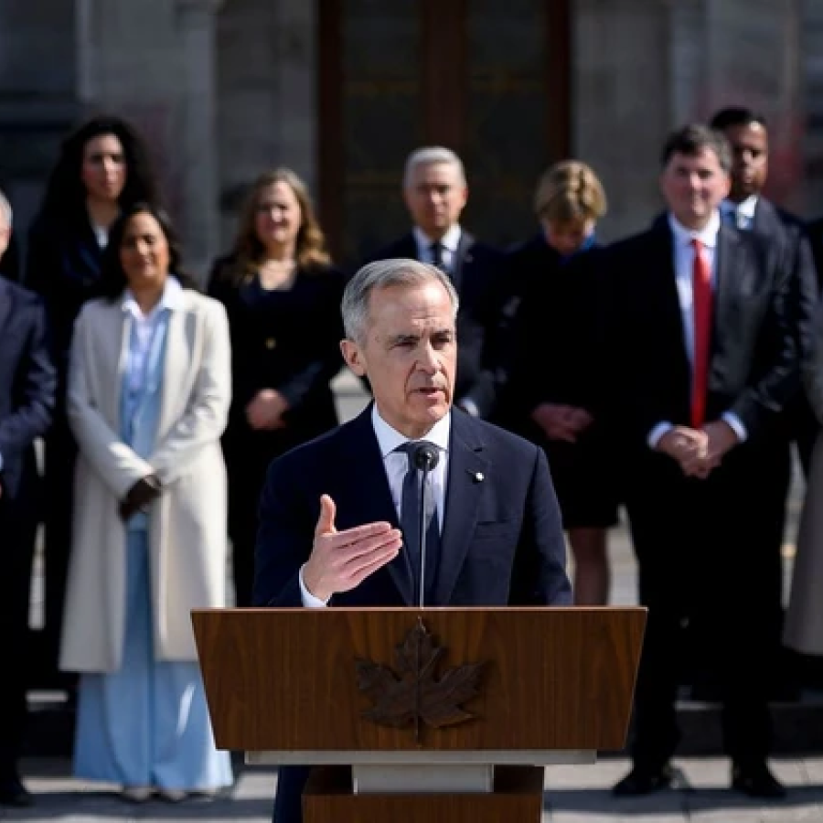 Mark Carney, Canada's prime minister, center, speaks to members of the media after a swearing-in ceremony